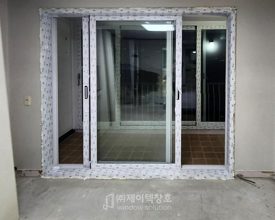 갈색 타일 바닥 위에 설치된 흰색 프레임 슬라이딩 창호