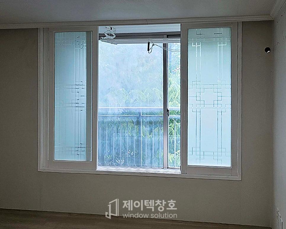 장식 패턴이 새겨진 유리 패널과 외부 식물이 보이는 창호
