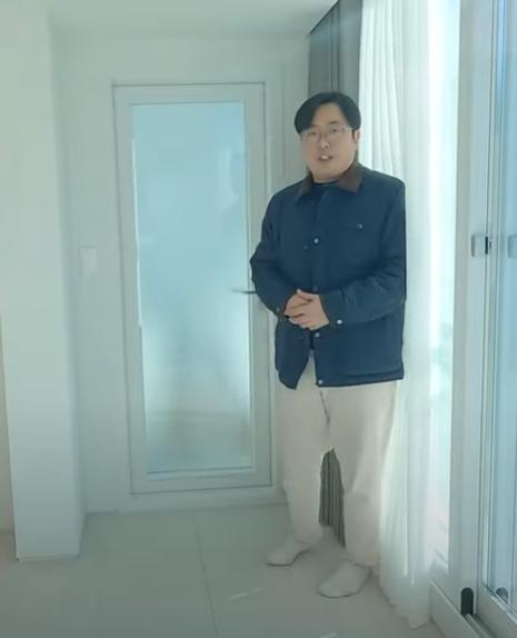 유리 패널 도어와 창문이 설치된 화이트 톤의 실내