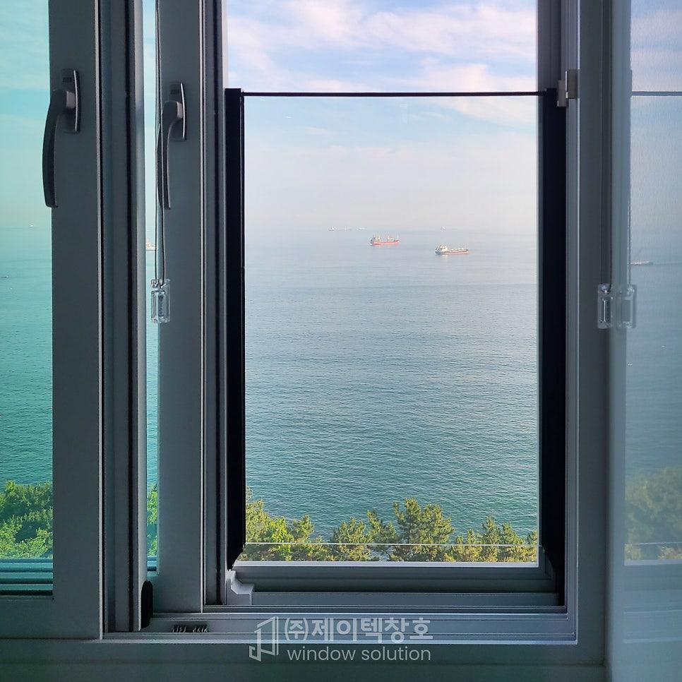 창 너머로 바다와 나무가 시원하게 보이는 개방감 있는 풍경
