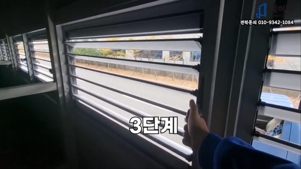 블라인드가 열려 외부 풍경이 보이는 창호 조작 모습