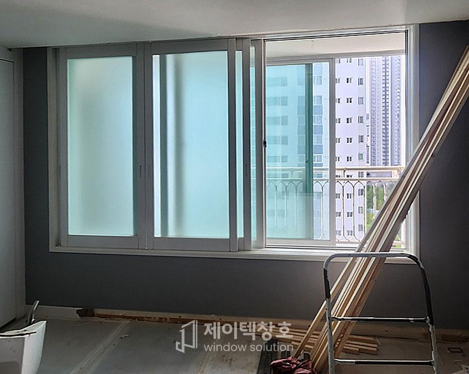 회색 벽과 흰 바닥 위로 자재들이 놓인 시공 중인 공간