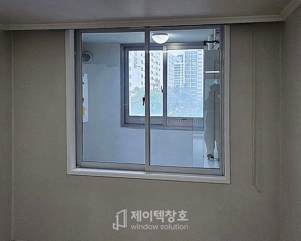 실내 벽면에 설치된 슬라이딩 유리문과 외부 풍경
