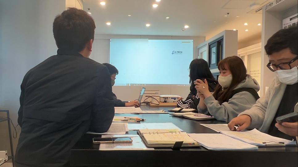 스크린과 서류가 놓인 회의실 내부 전경