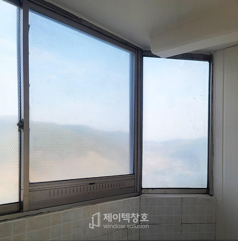 격자 필름이 부착된 금속 창틀과 하단 타일 바닥