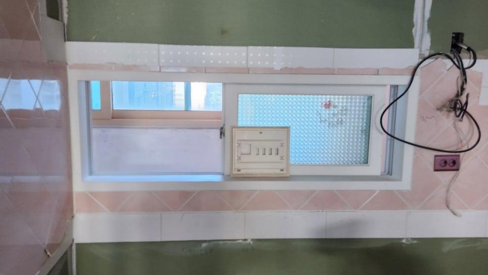 분홍색 타일 벽면과 창호, 노출된 전선