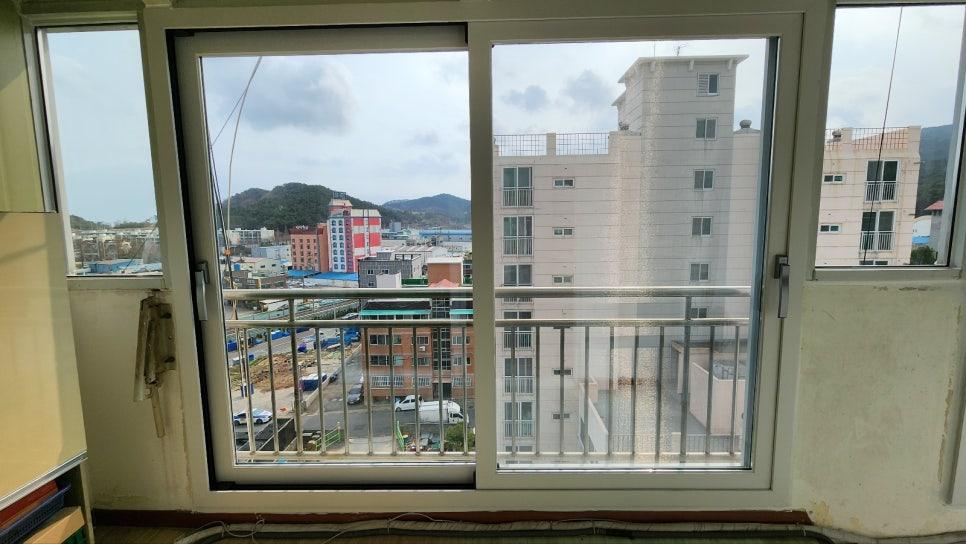 흰색 벽지와 금속 레일이 보이는 창가 공간