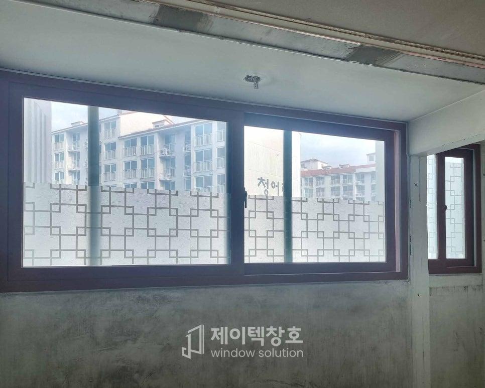 보호 필름이 부착된 유리 패널과 외부 건물 풍경