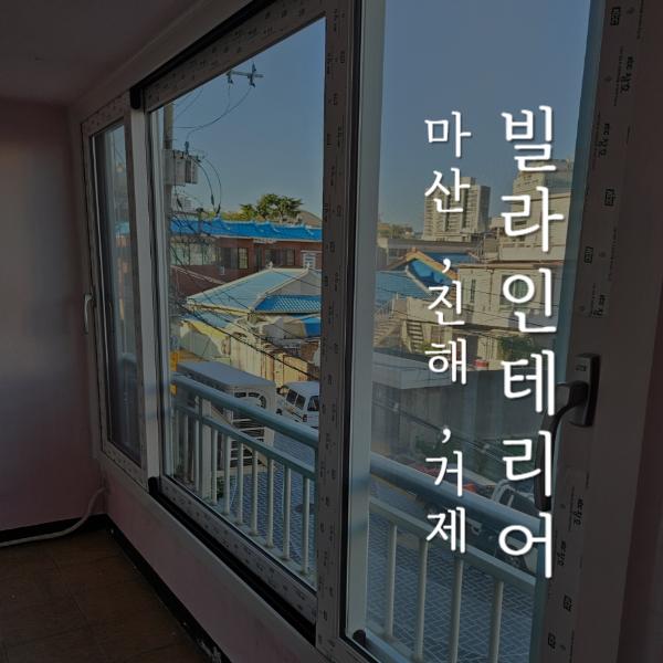 창호 테두리와 외부 건물이 보이는 발코니 시공 모습