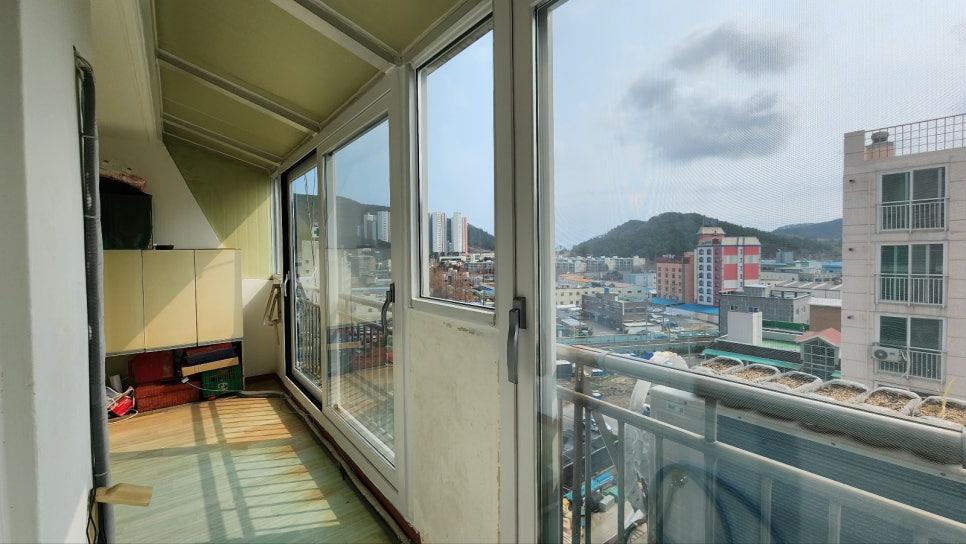 목재 바닥과 베이지색 수납장이 있는 창가 모습