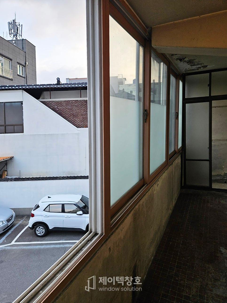 갈색 프레임 창호가 설치된 검은색 타일 발코니