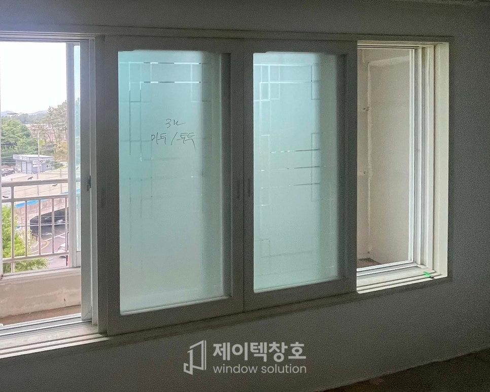 열린 창문 너머로 보이는 외부 도로와 건물 전경