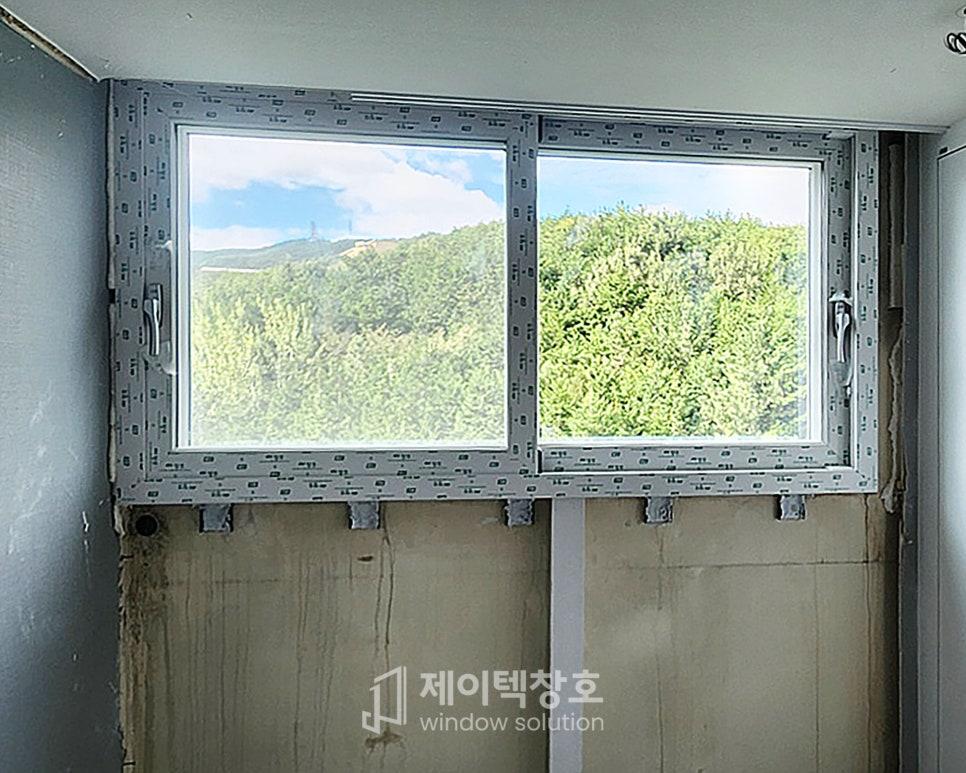 창 너머로 푸른 숲이 보이는 설치 모습