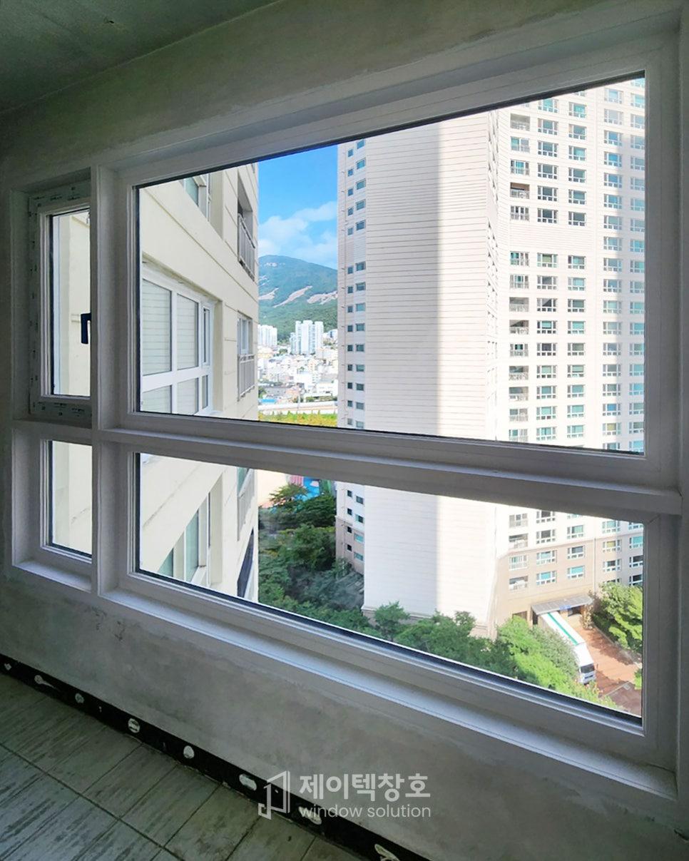 창 너머로 산과 도시 전경이 시원하게 들어오는 실내