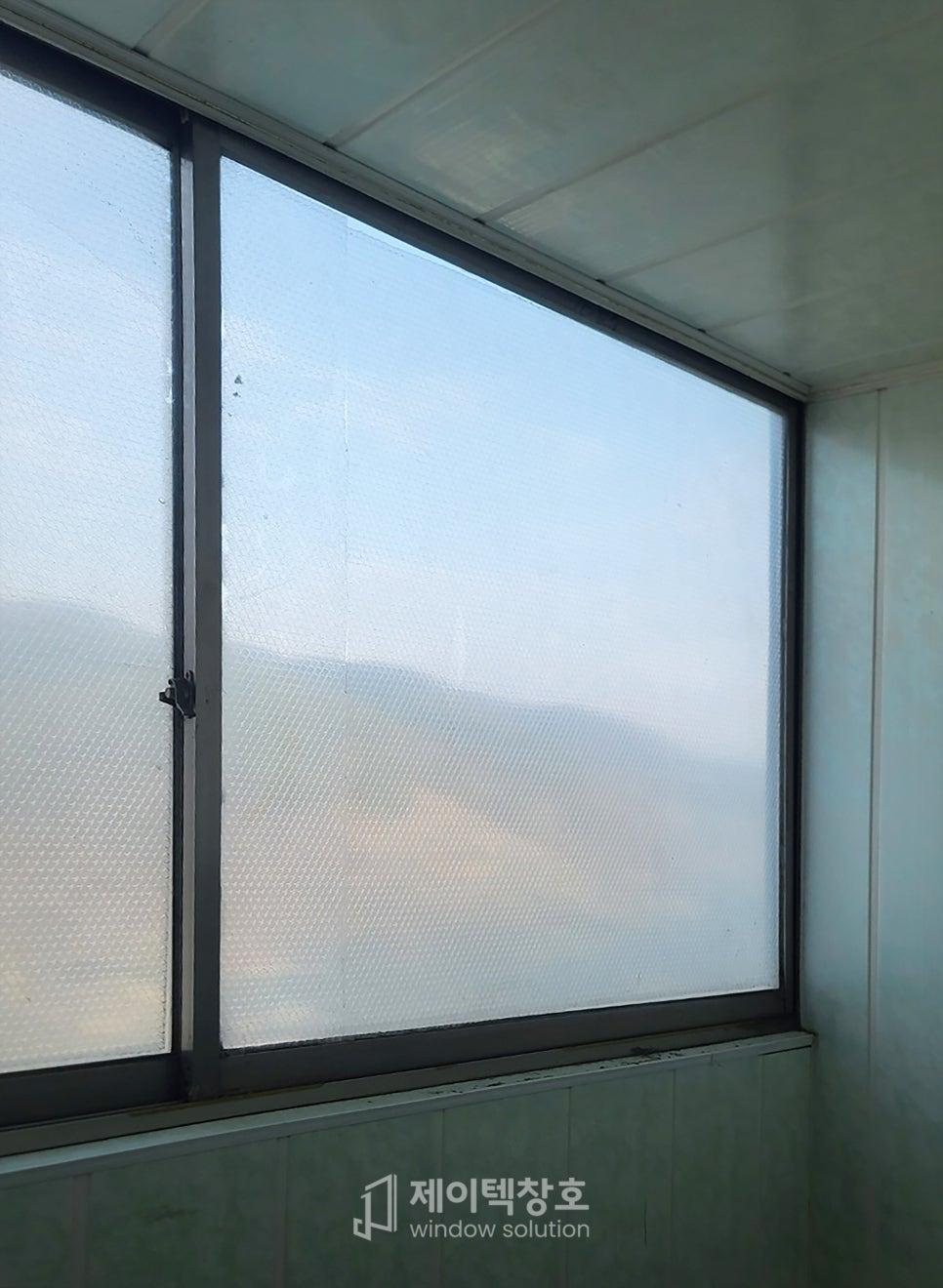 투명 격자 필름이 붙은 유리 패널과 하단 흰색 벽면