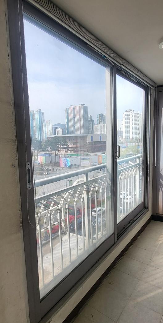 벽돌 벽과 타일 바닥 사이에 설치된 슬라이딩 유리창
