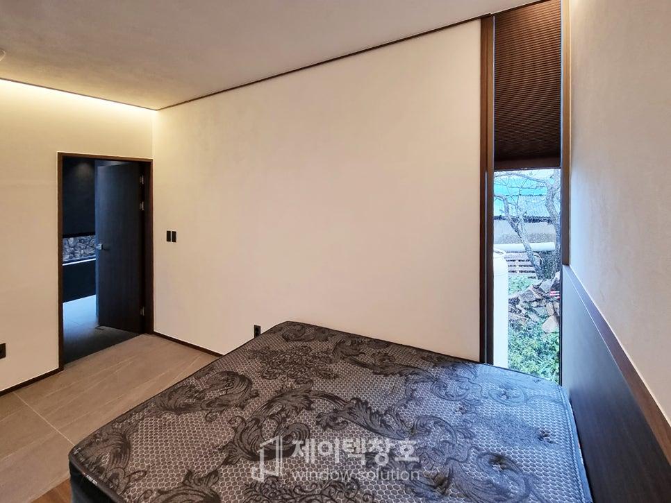 목재 바닥과 흰 벽으로 구성된 아늑한 침실 공간