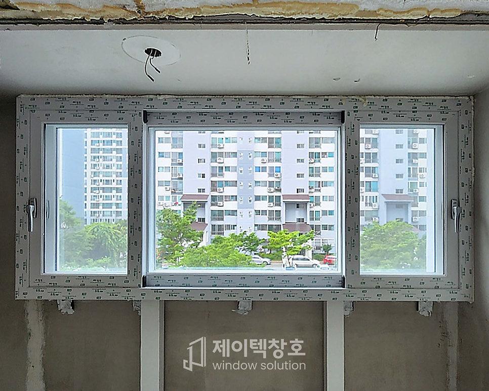 벽체에 고정된 창호 프레임과 외부 건물의 모습