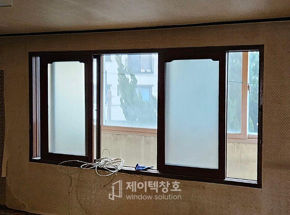 흰색 보호 필름이 부착된 창호와 노출된 전선