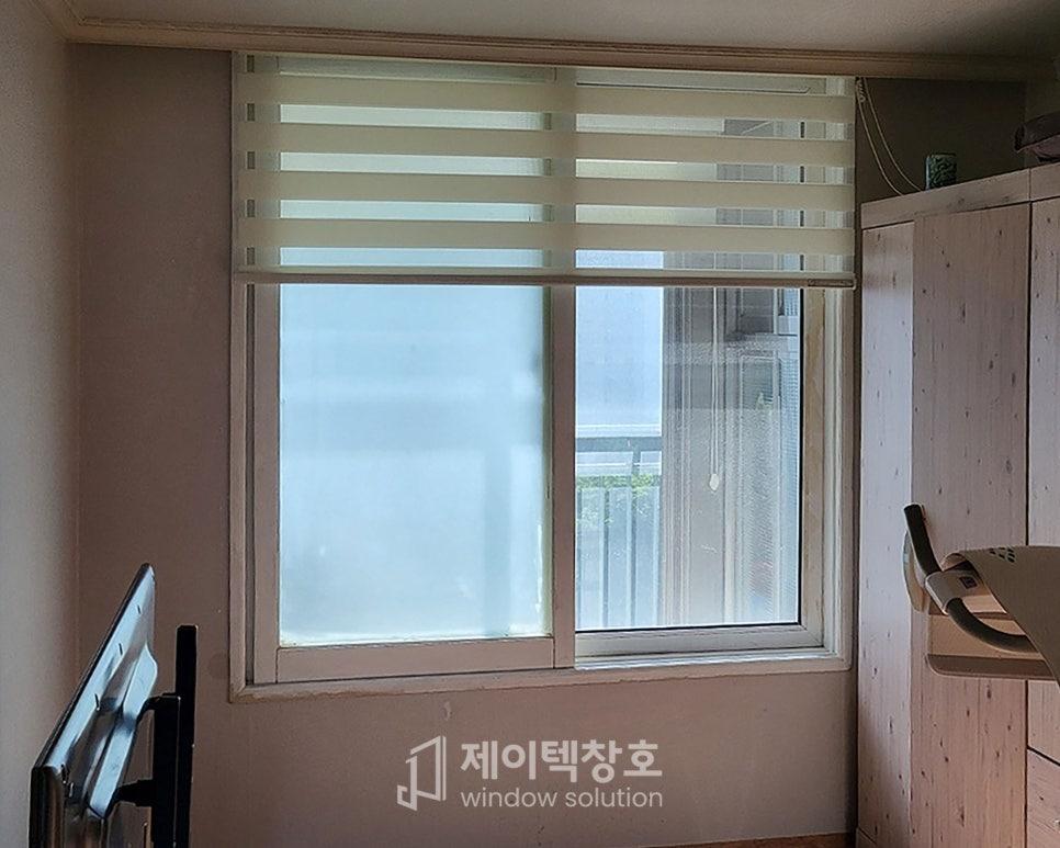 베이지색 벽면과 블라인드가 설치된 창호 상단