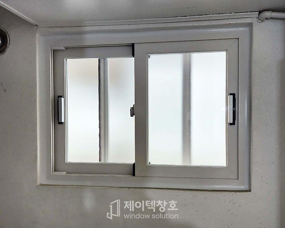 흰색 벽면에 부착된 창호 프레임과 유리 패널