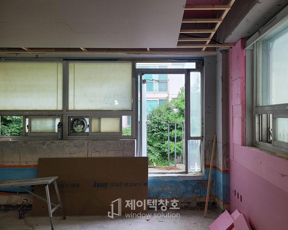 분홍색 벽면과 파란 테두리가 보이는 시공 중인 공간