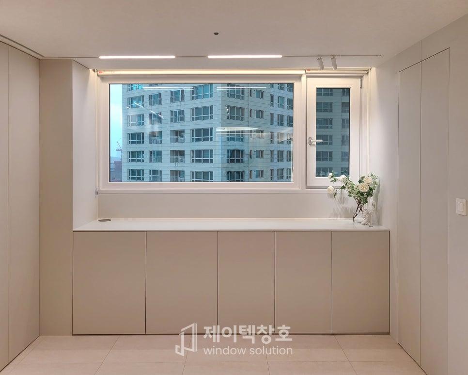 수납장과 꽃이 놓인 채광 좋은 주방 창가 모습