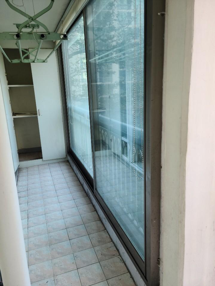 흰색 타일 바닥과 유리 슬라이딩 도어가 설치된 발코니