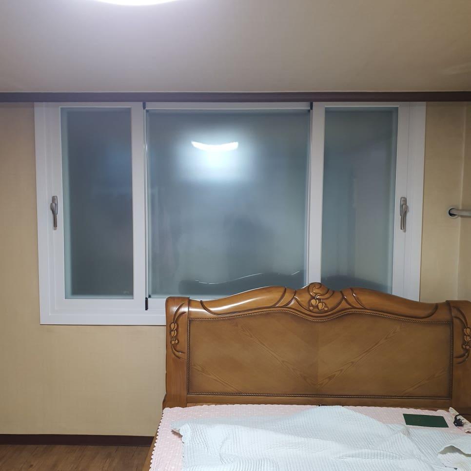베이지색 벽지와 흰색 프레임 창호가 설치된 안방
