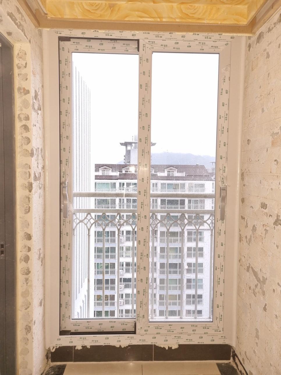 벽면 흠집과 보호 보드가 부착된 창호 설치 단계