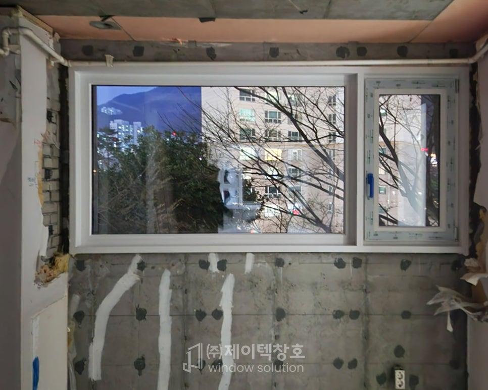 외부 건물과 나무가 보이는, 창호 설치 중인 현장이에요.