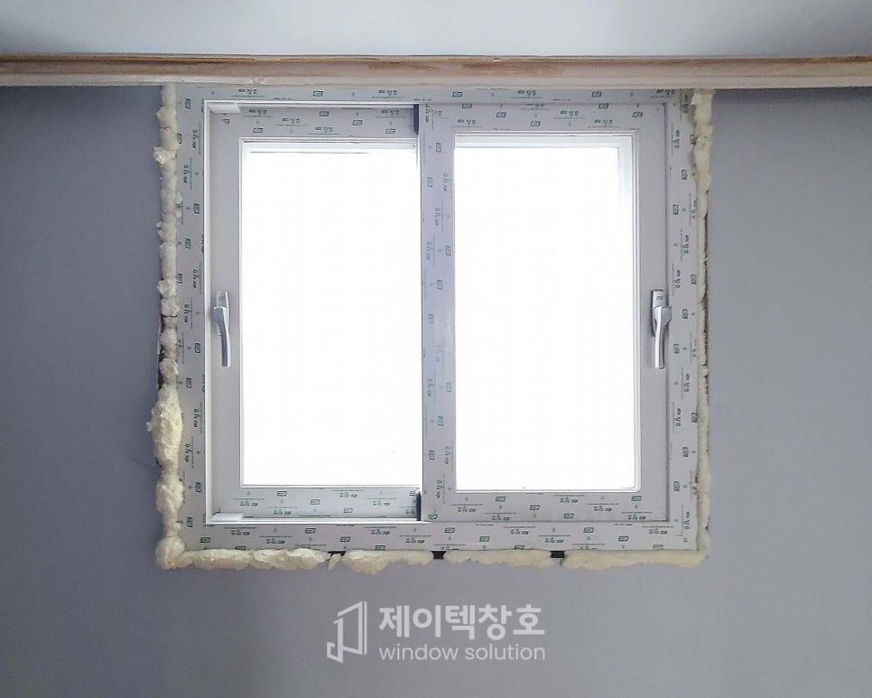 회색 벽면에 이중유리 창호를 고정하는 과정