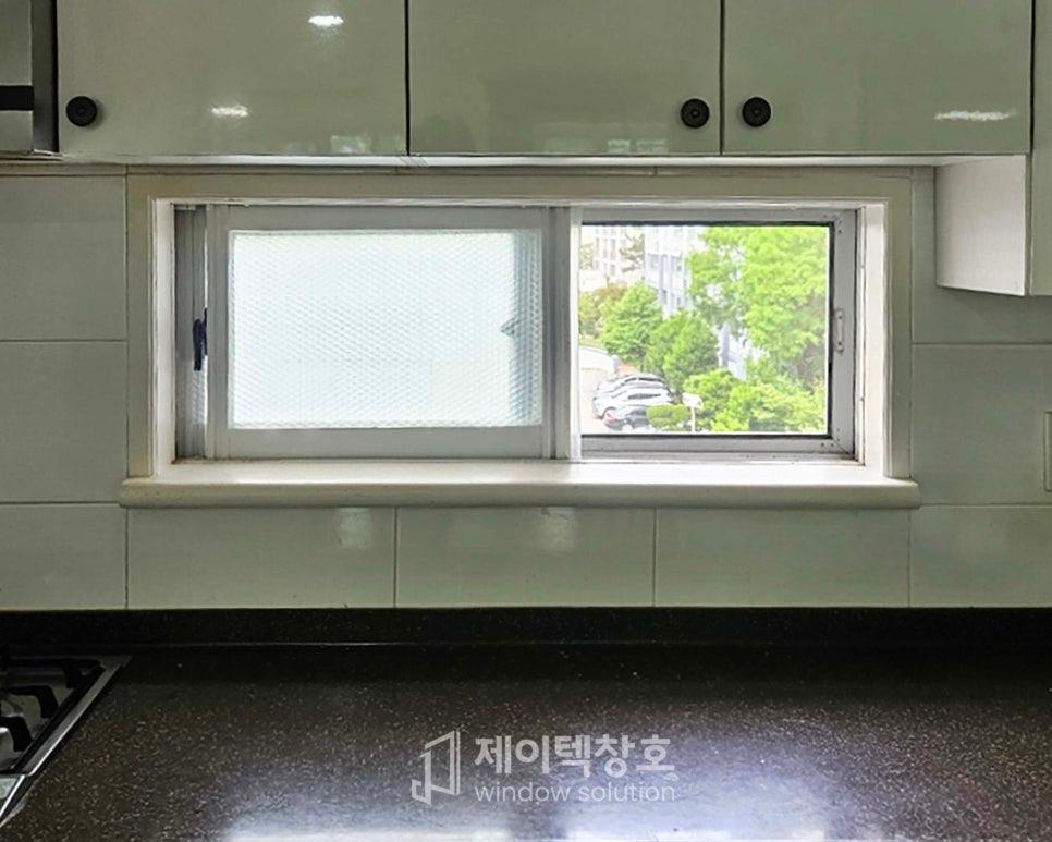 상부 수납장과 투명 유리창이 설치된 주방의 완성 모습