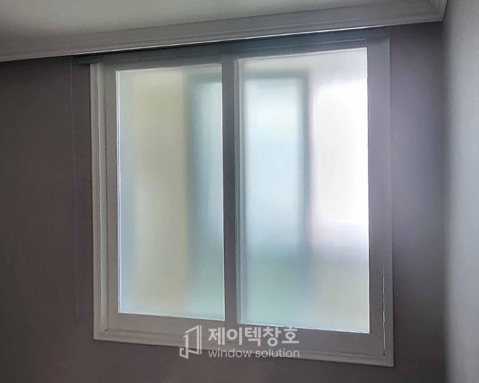 실내 벽면에 설치된 슬라이딩 창호가 보이며, 창호 유리 표면은 희미한 투명 처리로 마감됨. 창호 프레임은 베이지색 계열의 실내 벽면과 조화로 연결됨.