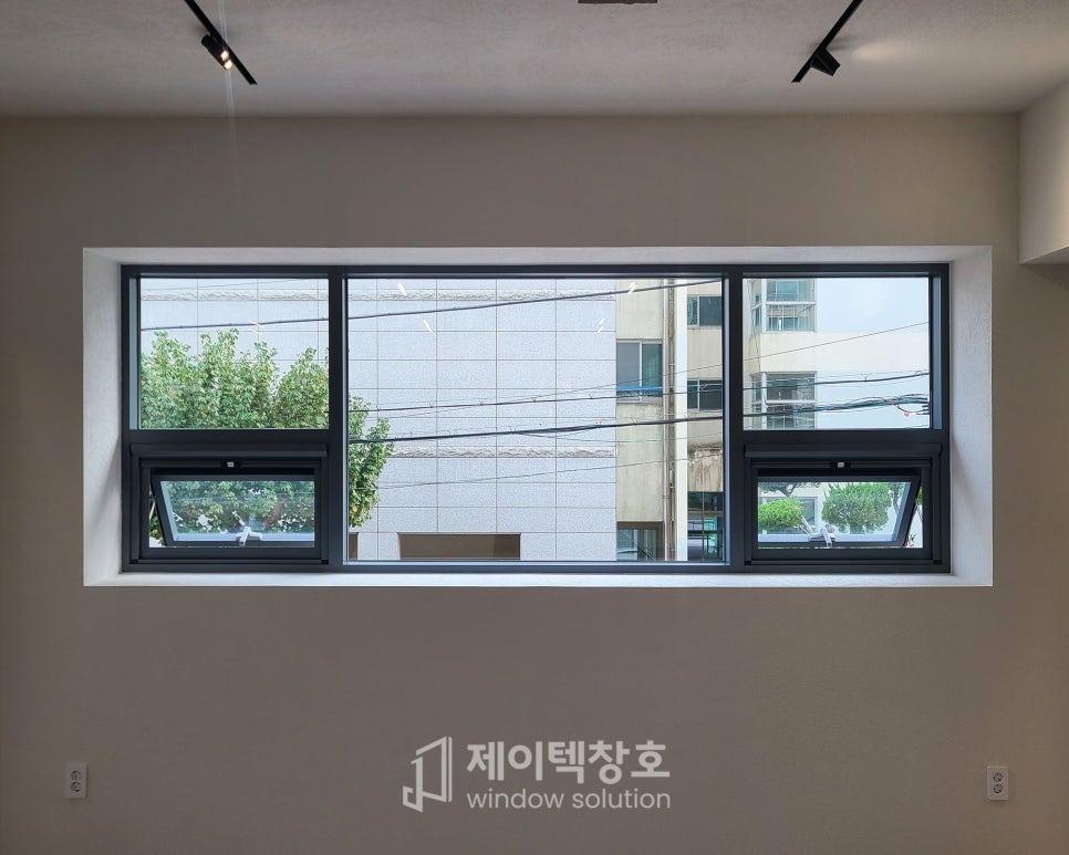 흰 벽에 설치된 검은 프레임의 창호
