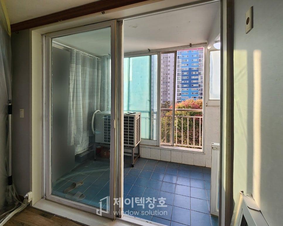 파란 타일 바닥과 흰색 난방기가 있는 슬라이딩 유리문 공간