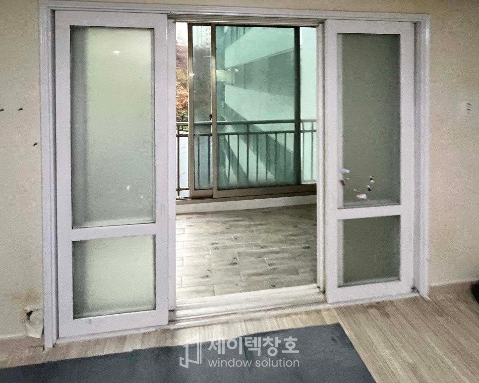 흰색 프레임의 슬라이딩 도어와 회색 타일 발코니