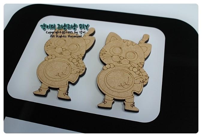 흰색 배경 위 고양이 모양 나무 인형 두 점
