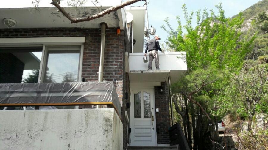베란다 상부와 외벽면에서 진행 중인 도장 작업