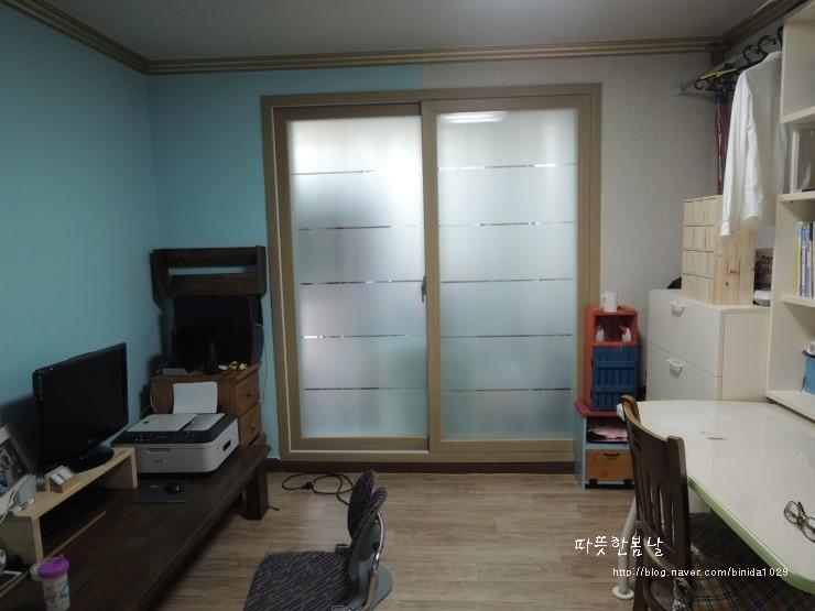 파란 벽면과 가구들이 배치된 서재 공간의 전경