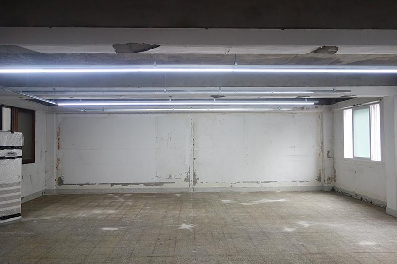 흰 벽과 콘크리트 바닥이 보이는 공사 초기 공간