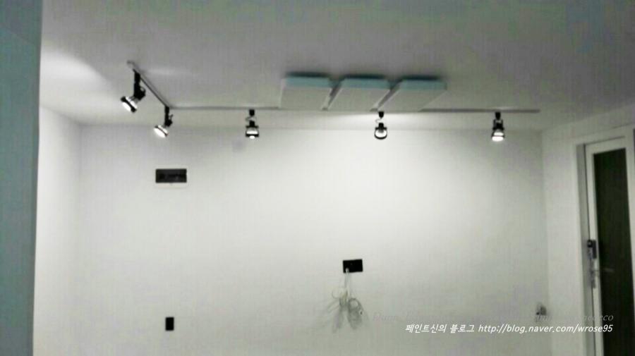 트랙 조명과 전기 케이블이 노출된 천장과 벽면