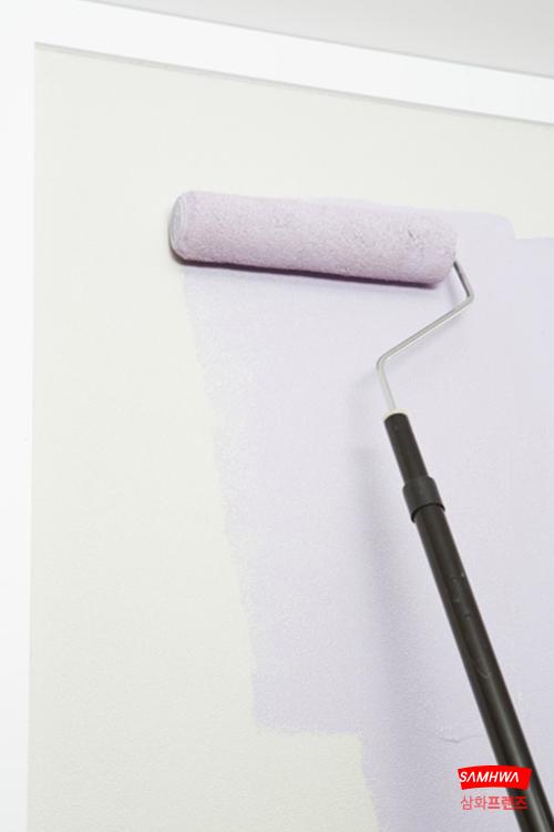 연보라색 페인트를 롤러로 칠하는 벽면