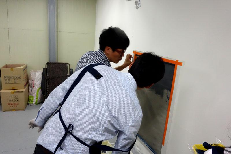 오렌지 테두리 유리판 옆에서 작업 중인 모습