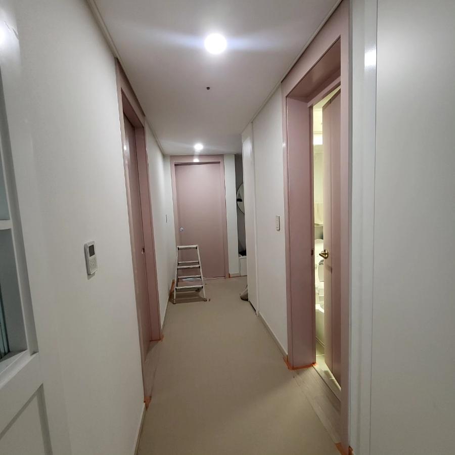 분홍색 프레임을 화이트로 바꾸기 위해 집중하고 있는 복도 작업 현장
