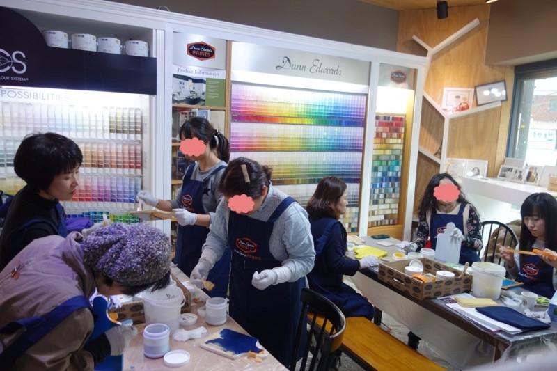소형 도구와 페인트 병이 놓인 시공 실습 장면