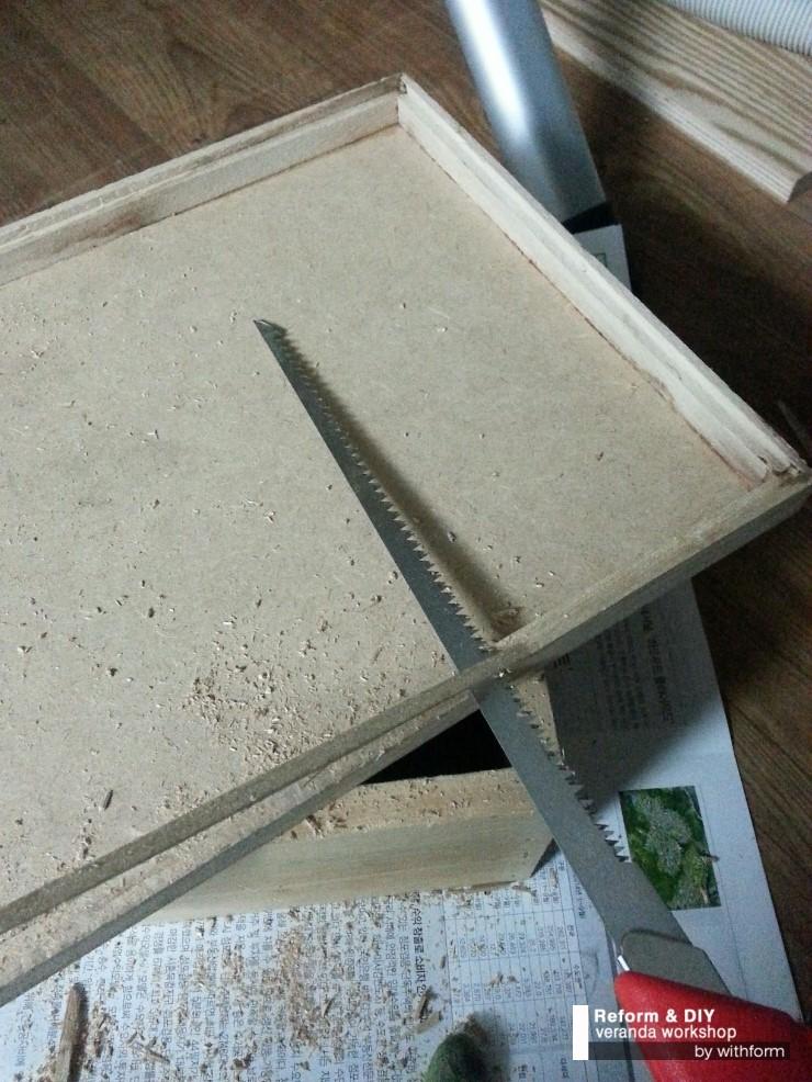 금속 톱날을 이용해 나무 보드를 절단하는 과정