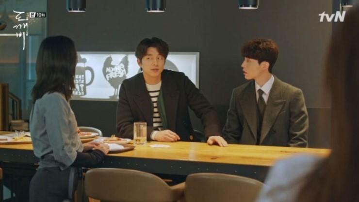 다크 그린 벽면과 나무 가구가 배치된 식당 공간