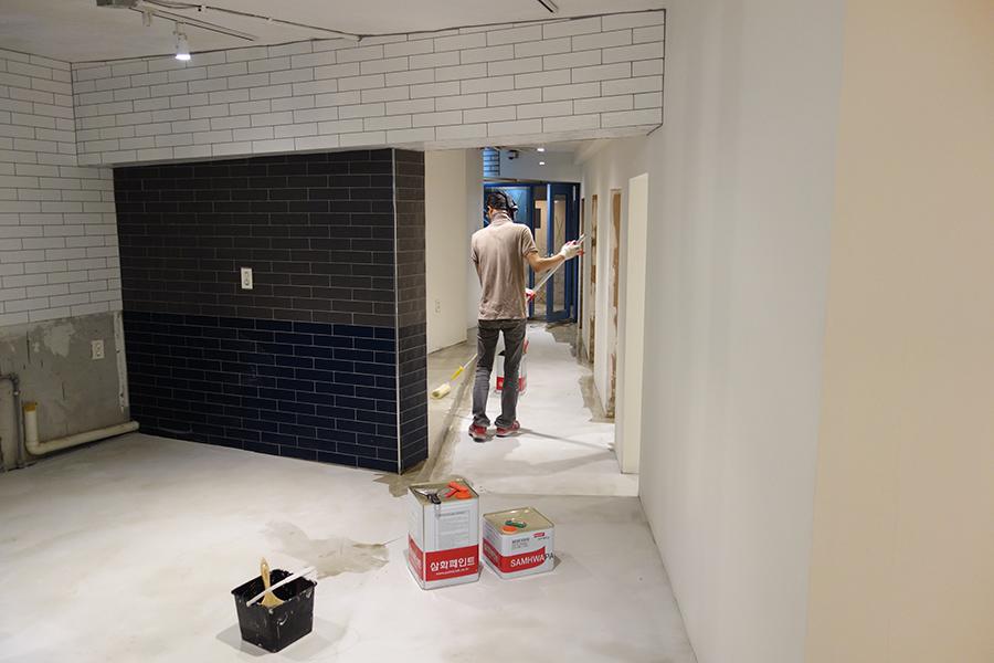 흰색 벽과 타일 벽이 있는 복도 공간의 모습