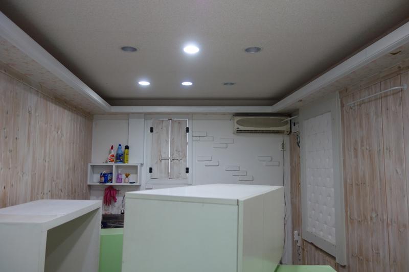 LED 조명과 냉방기가 설치된 목재 패널 벽면